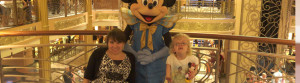 Mom in wheelchair and her daughter posing with Mickey Mouse