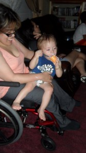Mother sitting in wheelchair holding her young son