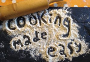 Rolling pin with flour. Cooking made easy written with flour on counter