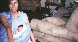 Photo shows mom in wheelchair holding baby using a baby carrier sling