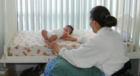 Photo of mother in wheelchair and baby in accessible crib.