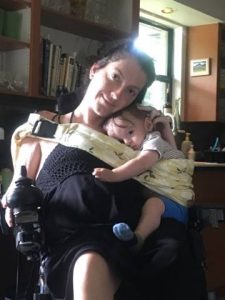 Photo of mother in wheelchair holding son with ring sling