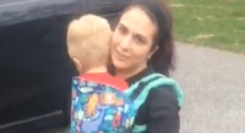 Woman in wheelchair wearing baby carrier with son