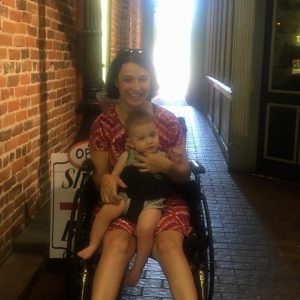 Woman in wheelchair with baby strapped to her lap